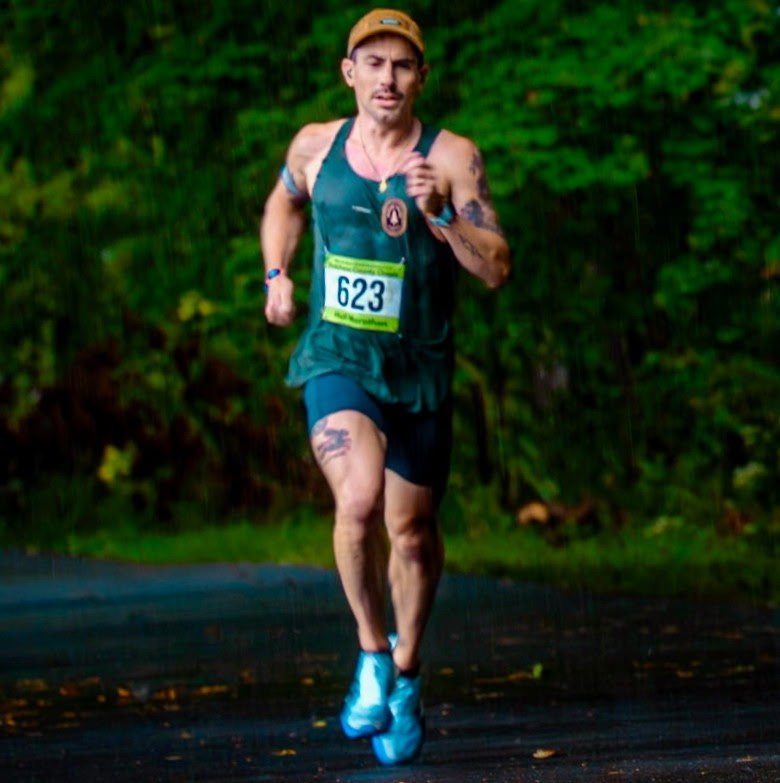Ryan Carney racing in a Hudson Valley Track Club singlet in the rain