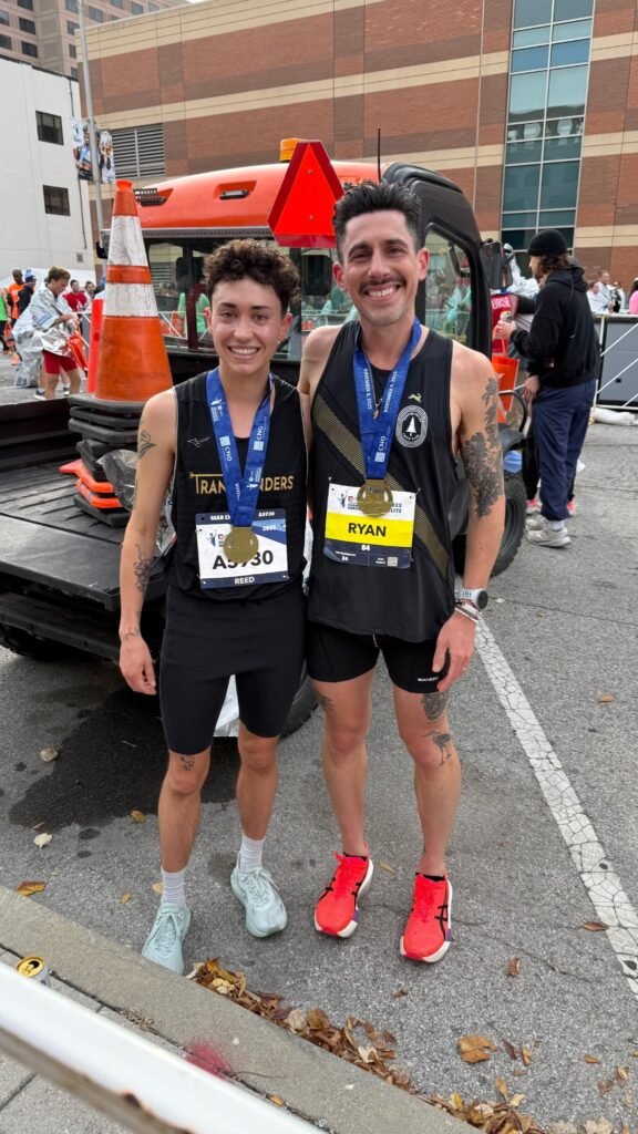 Ryan Carney and one of his athletes with their medals after the Indianapolis Monumental Marathon